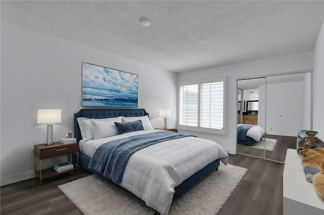 bedroom with a closet, baseboards, and wood finished floors