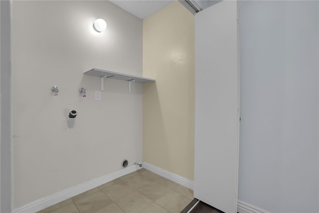 clothes washing area with light tile patterned floors, baseboards, gas dryer hookup, hookup for a washing machine, and laundry area