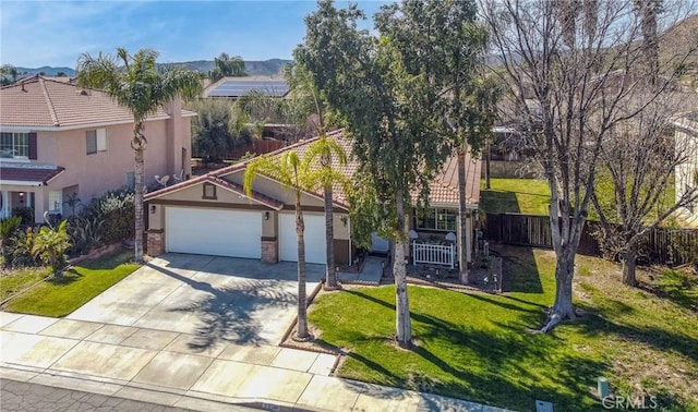 view of front facade with fence, driveway, stucco siding, a front lawn, and a garage