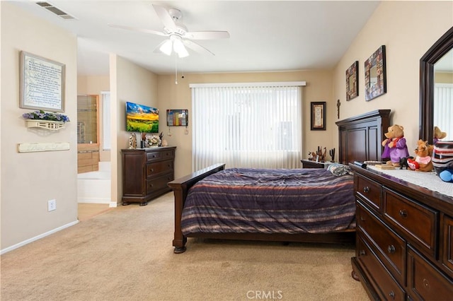 bedroom featuring a ceiling fan, visible vents, baseboards, ensuite bath, and light colored carpet