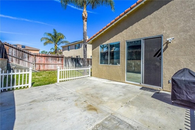 view of patio with fence and a grill