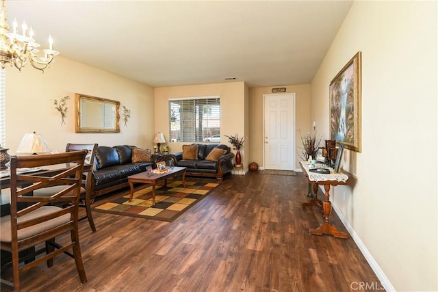 living area with dark wood-style floors, baseboards, and a chandelier