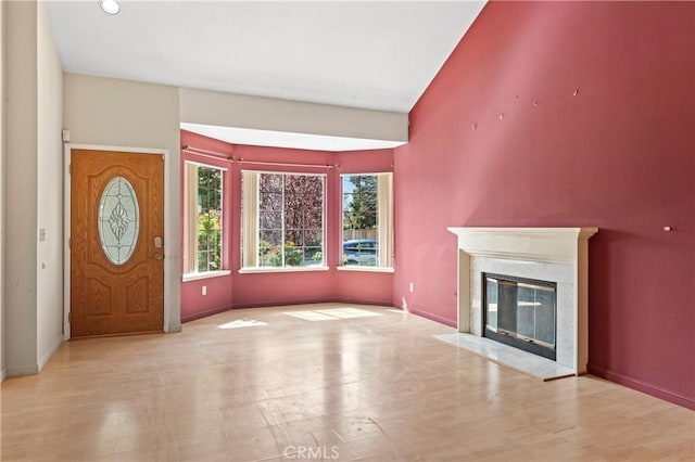 interior space with a premium fireplace, baseboards, and wood finished floors