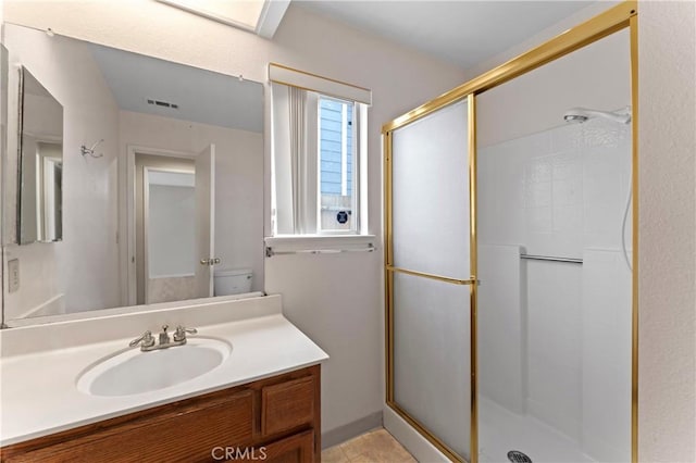 full bath featuring visible vents, vanity, and a shower stall