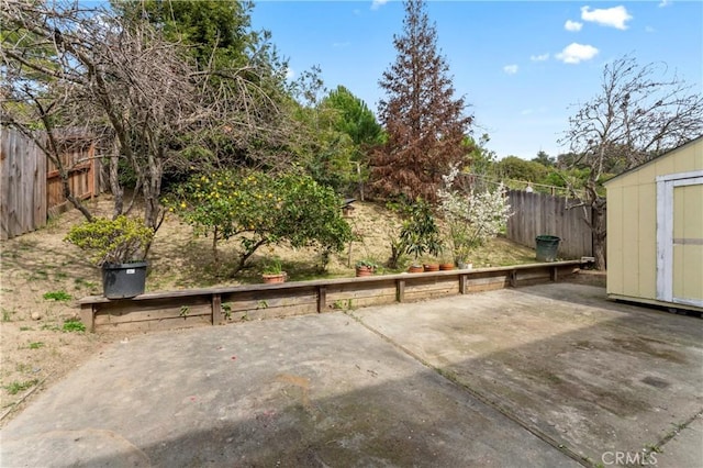 view of patio featuring an outbuilding, a storage unit, and a fenced backyard