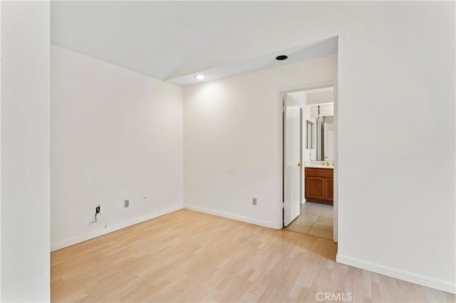 spare room featuring light wood-style flooring and baseboards