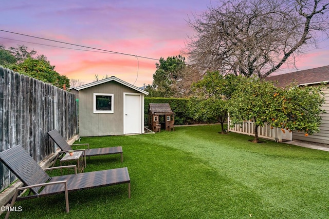 view of yard with an outbuilding, a storage shed, and a fenced backyard