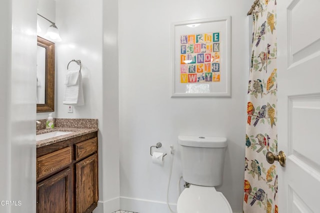 full bathroom with toilet, vanity, and baseboards