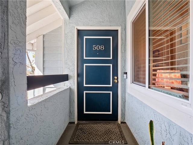 view of exterior entry with stucco siding