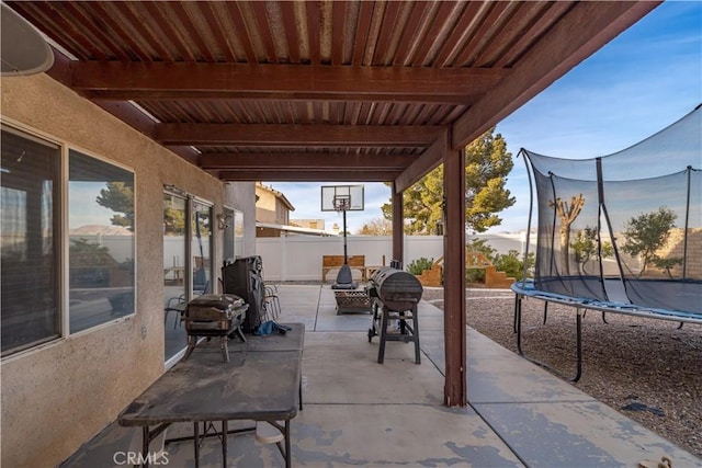 view of patio featuring a trampoline and fence