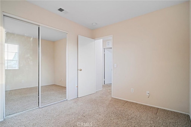 unfurnished bedroom featuring a closet, visible vents, and carpet