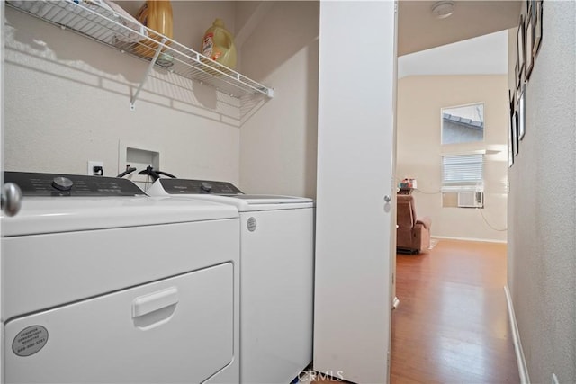 laundry room with laundry area, light wood-style floors, baseboards, and washing machine and clothes dryer