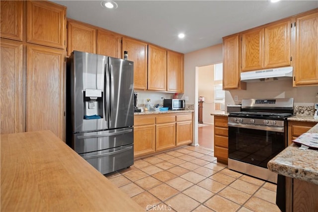 kitchen with under cabinet range hood, appliances with stainless steel finishes, light tile patterned flooring, and recessed lighting