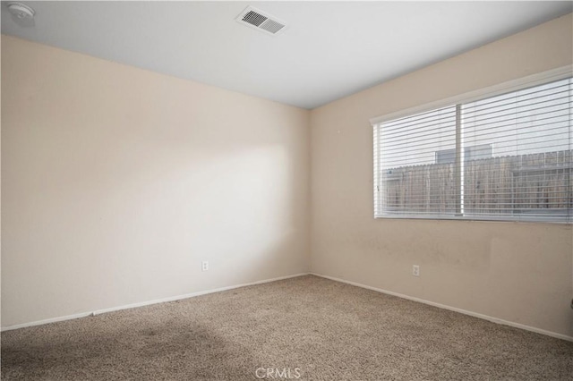 carpeted spare room with baseboards and visible vents