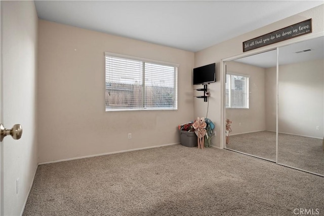 unfurnished bedroom with visible vents, carpet, and a closet