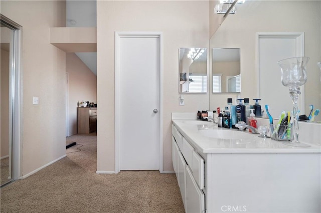 full bathroom with double vanity, baseboards, carpet floors, and a sink