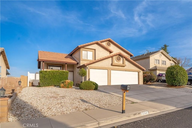 view of front of home with an attached garage, fence, stucco siding, driveway, and a gate