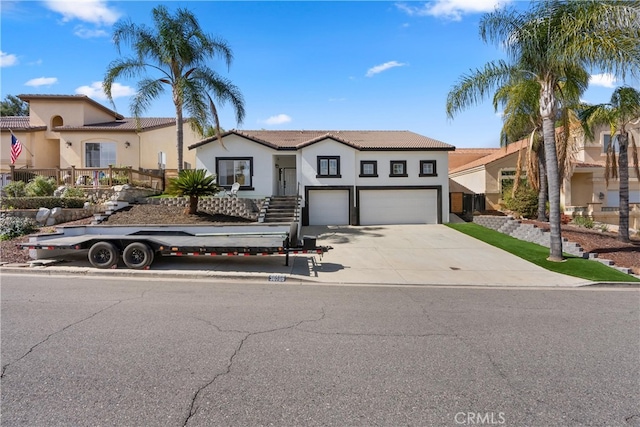 view of front of property with stucco siding, concrete driveway, and a garage