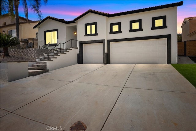 mediterranean / spanish-style home with stucco siding, an attached garage, and concrete driveway