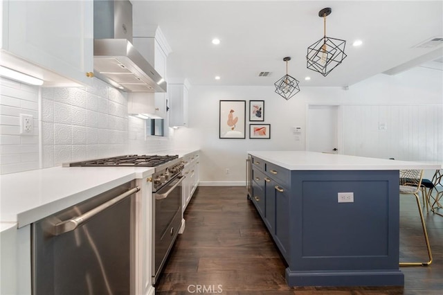 kitchen with visible vents, backsplash, wall chimney range hood, stainless steel appliances, and blue cabinets