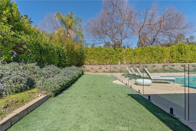 view of yard featuring a patio area, a fenced in pool, and fence