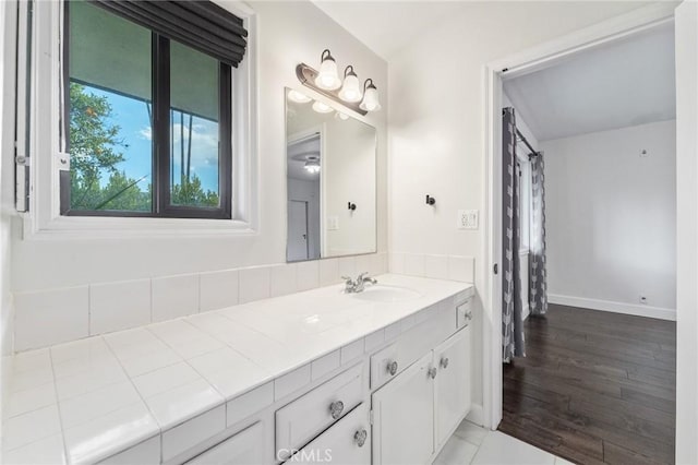 bathroom featuring vanity, baseboards, and wood finished floors