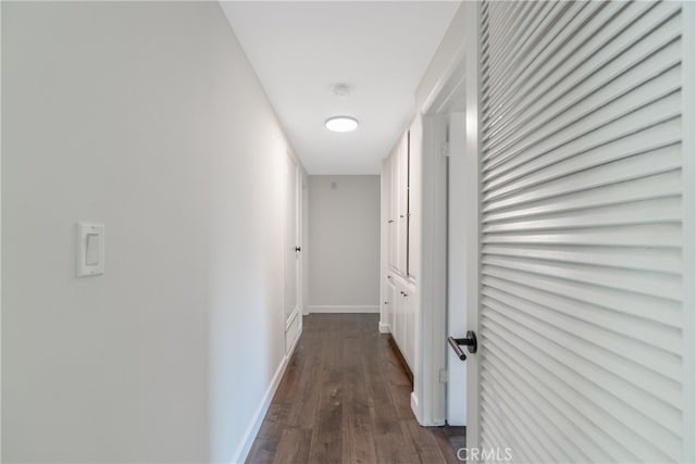 hallway with dark wood finished floors and baseboards