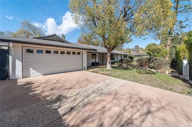 single story home featuring a garage, concrete driveway, and stucco siding