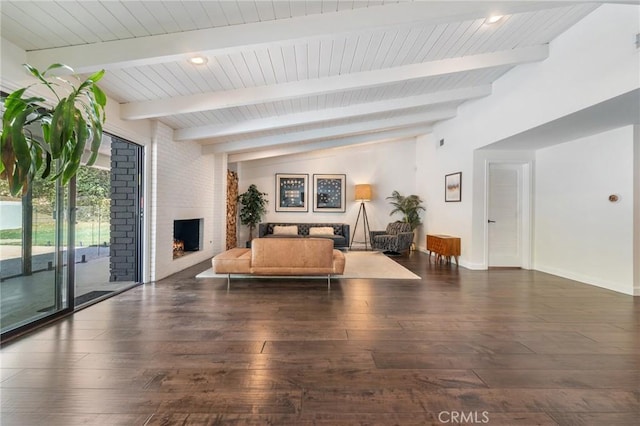 living room featuring baseboards, a brick fireplace, wood finished floors, and vaulted ceiling with beams