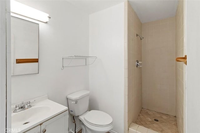 full bathroom featuring vanity, toilet, and tiled shower