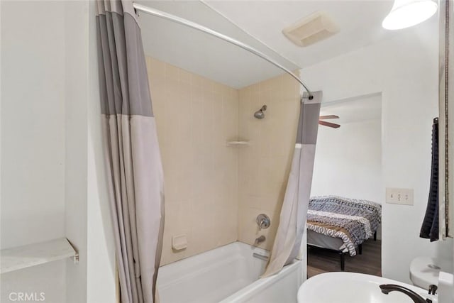 bathroom featuring shower / tub combo with curtain and toilet