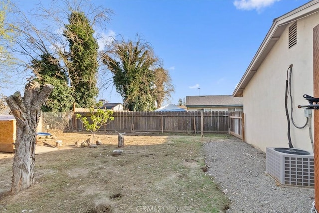 view of yard with a fenced backyard and central AC