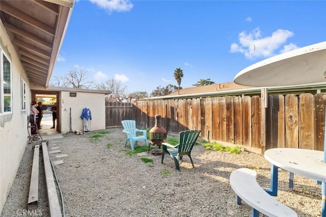 view of yard featuring a fire pit and fence