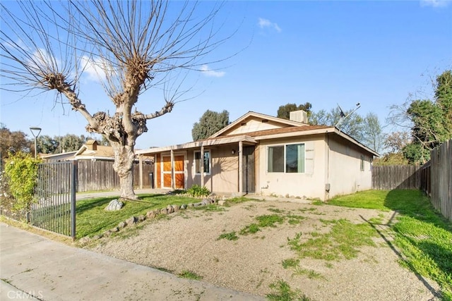 bungalow-style house with stucco siding, a front lawn, a chimney, and a fenced backyard