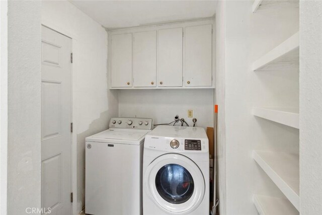 washroom featuring washer and dryer and cabinet space