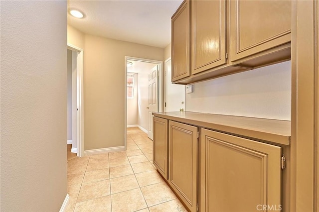 kitchen featuring light tile patterned flooring, light countertops, and baseboards