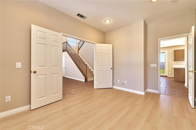 unfurnished bedroom with visible vents, baseboards, and light wood-style flooring