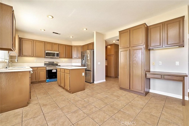 kitchen with a kitchen island, baseboards, light countertops, appliances with stainless steel finishes, and a sink