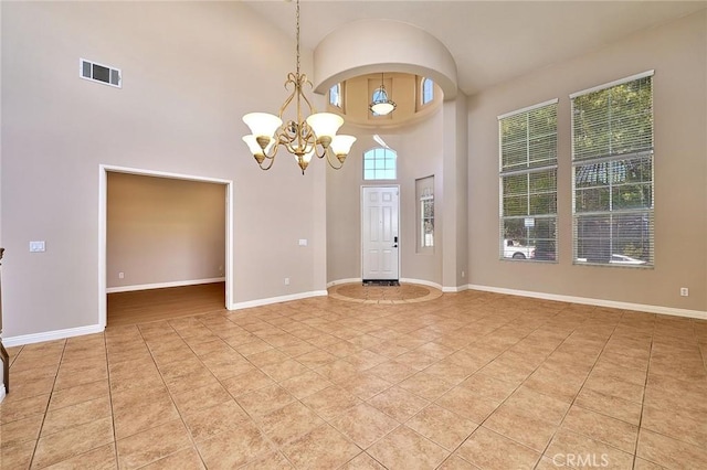 interior space featuring light tile patterned flooring, visible vents, baseboards, and an inviting chandelier