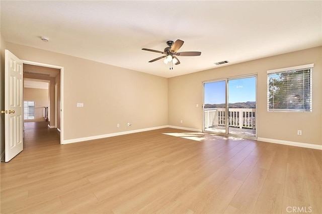 empty room featuring ceiling fan, visible vents, baseboards, and light wood-style flooring