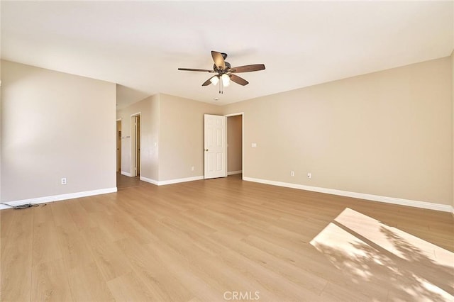 empty room featuring light wood-style flooring, a ceiling fan, and baseboards