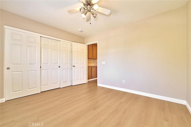 unfurnished bedroom with a closet, baseboards, light wood finished floors, and ceiling fan