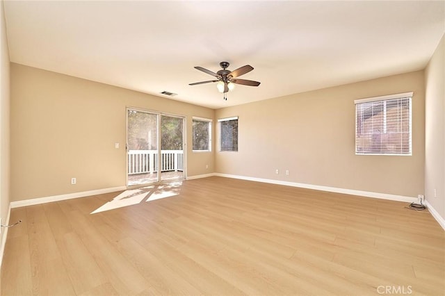 spare room featuring visible vents, light wood-style flooring, baseboards, and a ceiling fan