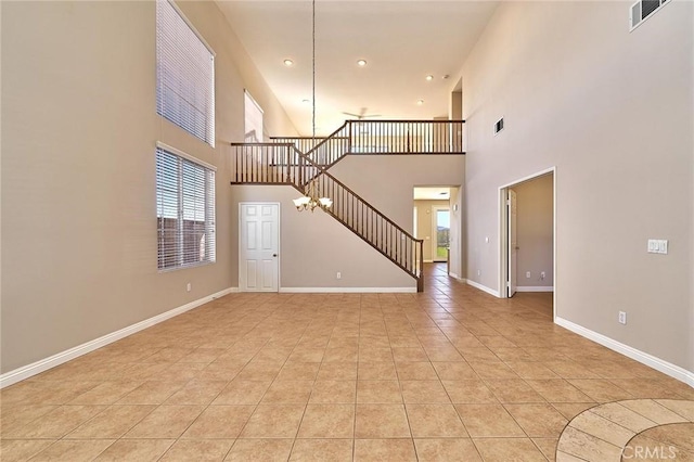 unfurnished living room featuring a healthy amount of sunlight, visible vents, and baseboards