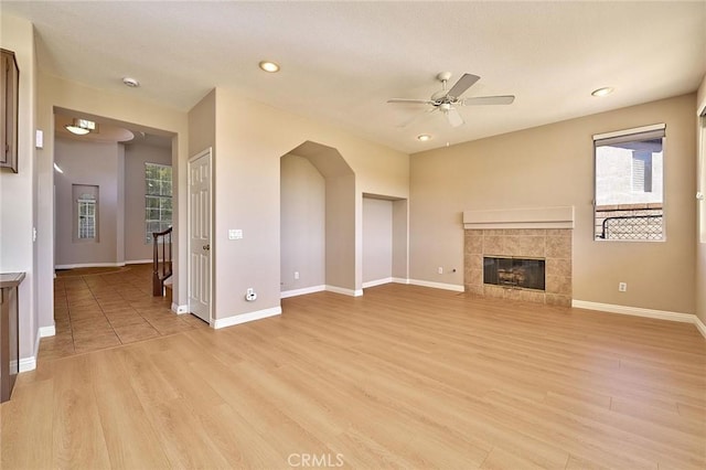 unfurnished living room featuring baseboards, light wood-style flooring, and a ceiling fan