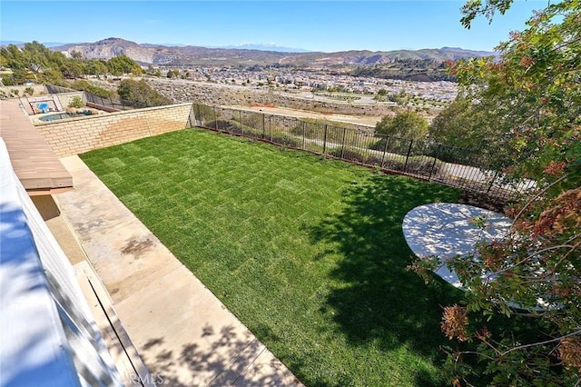 view of yard with a fenced backyard and a mountain view