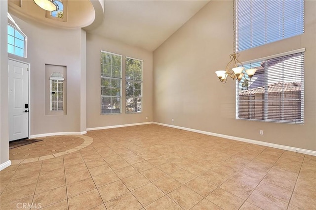 entrance foyer featuring light tile patterned floors, baseboards, and high vaulted ceiling