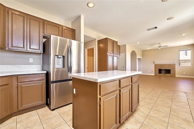 kitchen with a ceiling fan, light tile patterned flooring, visible vents, and stainless steel fridge