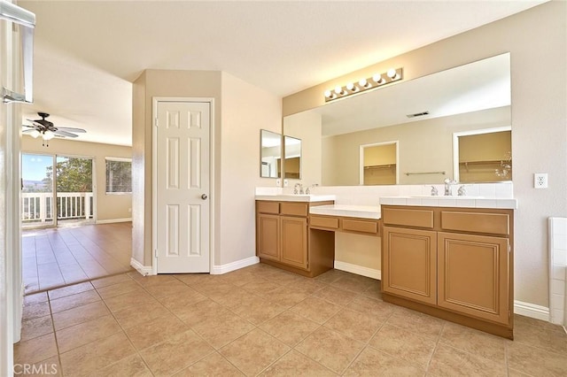 bathroom featuring tile patterned flooring, double vanity, baseboards, and ceiling fan