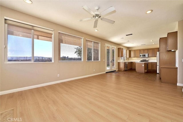 unfurnished living room featuring visible vents, recessed lighting, light wood-style floors, baseboards, and ceiling fan